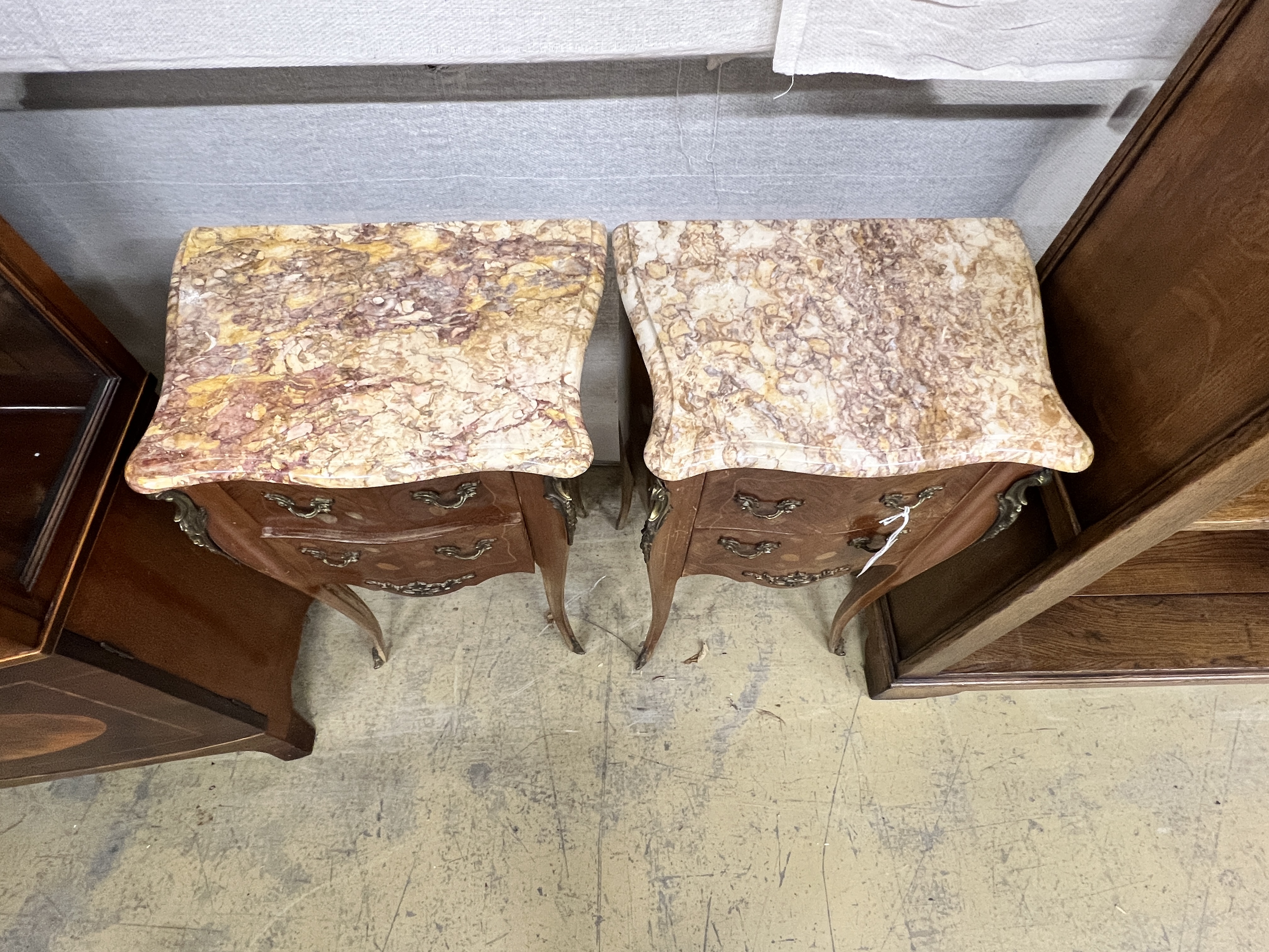 A pair of Louis XVI style inlaid kingwood marble top serpentine bedside chests, width 45cm, depth 31cm, height 73cm